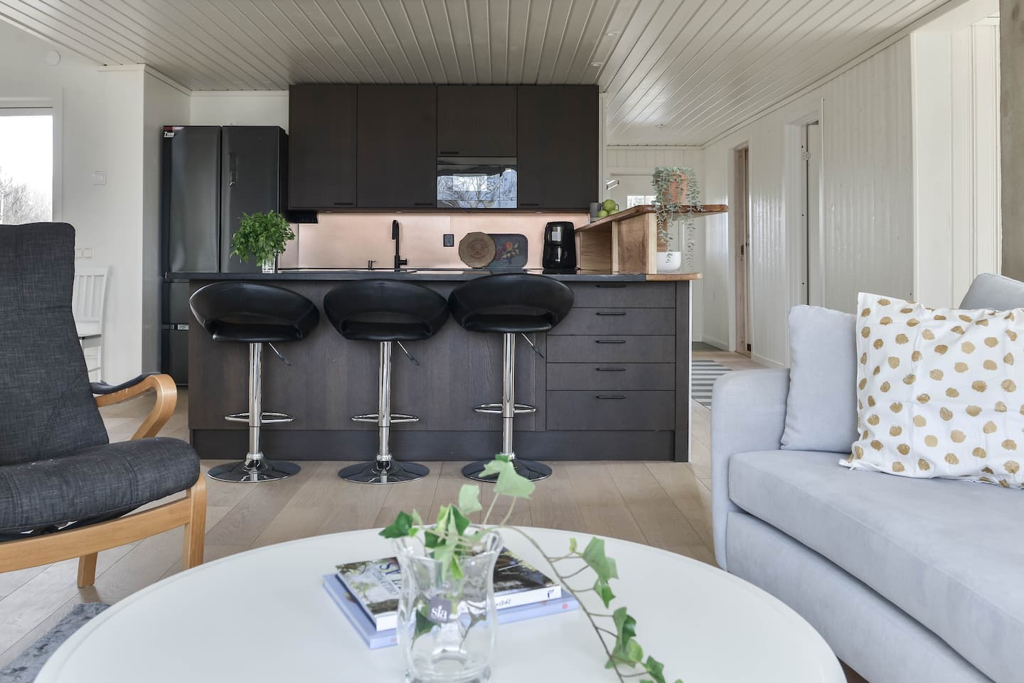 Open-plan kitchen with bar stools and living area